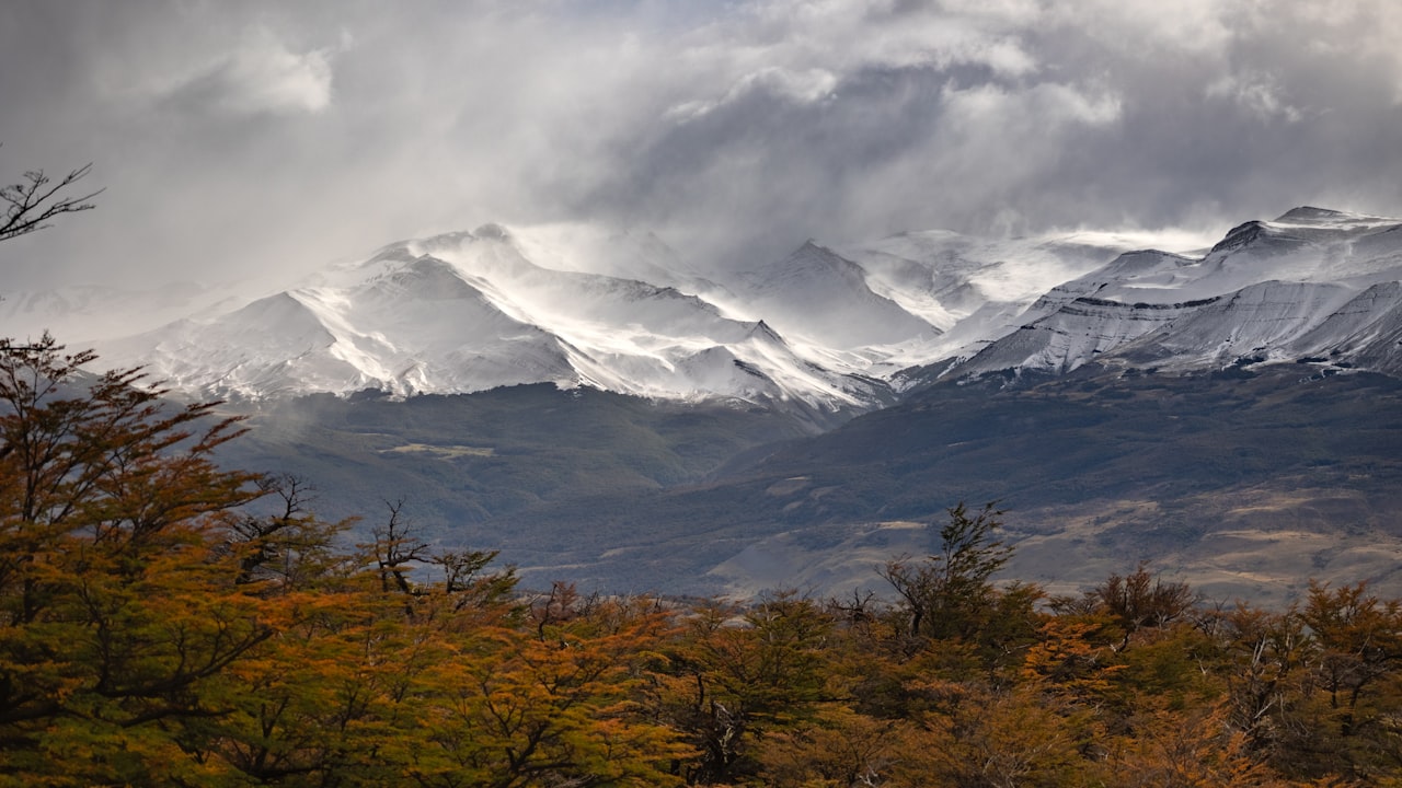 Montañas nevadas bajo un cielo nublado y tormentoso durante una jornada de frío intenso.