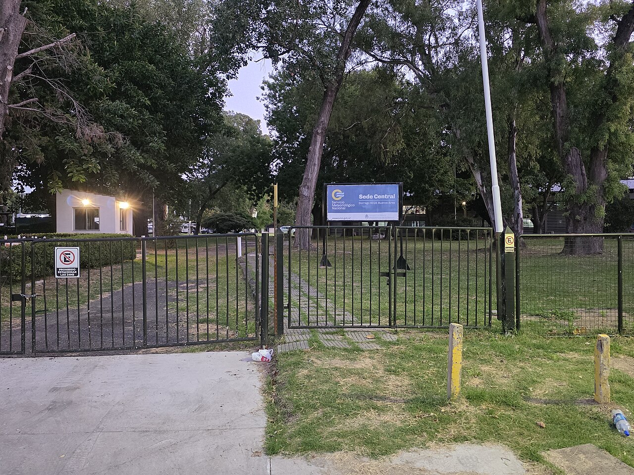 Entrada principal de la sede del Servicio Meteorológico Nacional con árboles y cielo despejado.