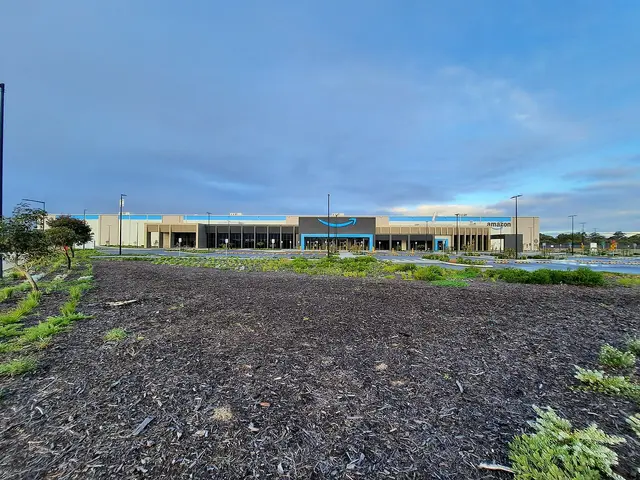 Vista exterior de un centro de distribución de Amazon con el logo visible en la fachada.