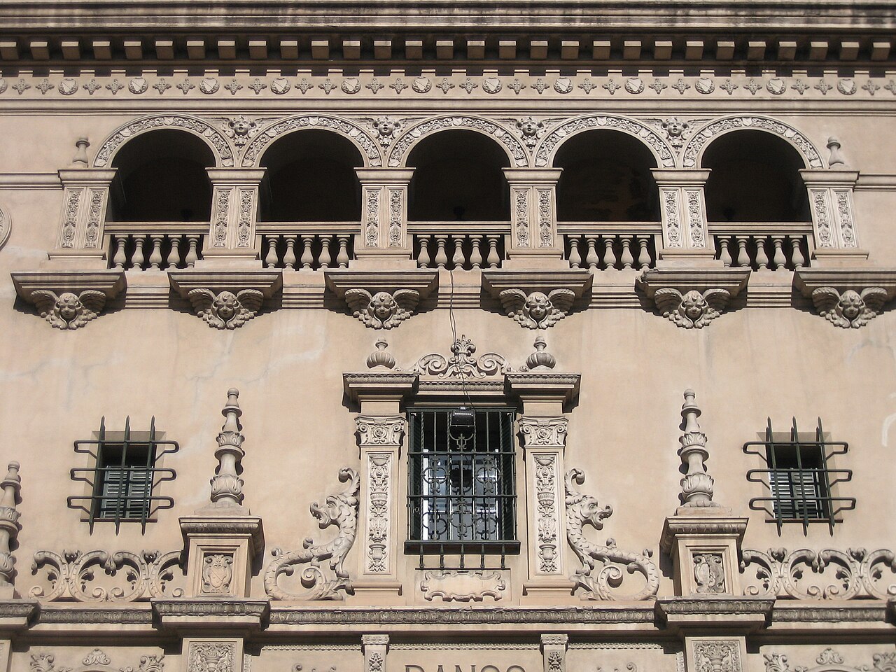 Fachada de un edificio histórico con arcos y detalles arquitectónicos ornamentados en la ciudad de Mendoza.