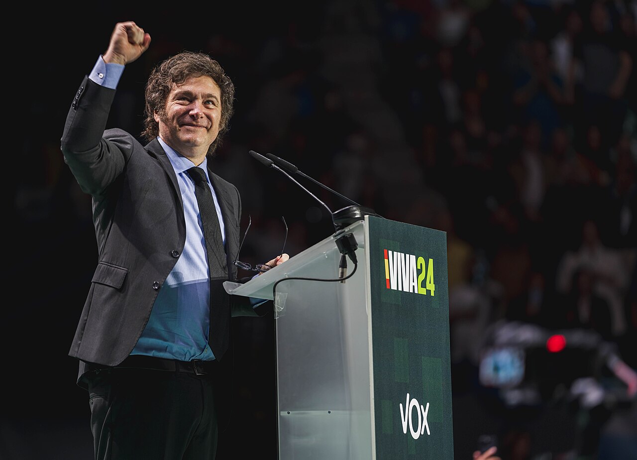 El presidente Javier Milei habla detrás de un atril durante un evento político internacional.