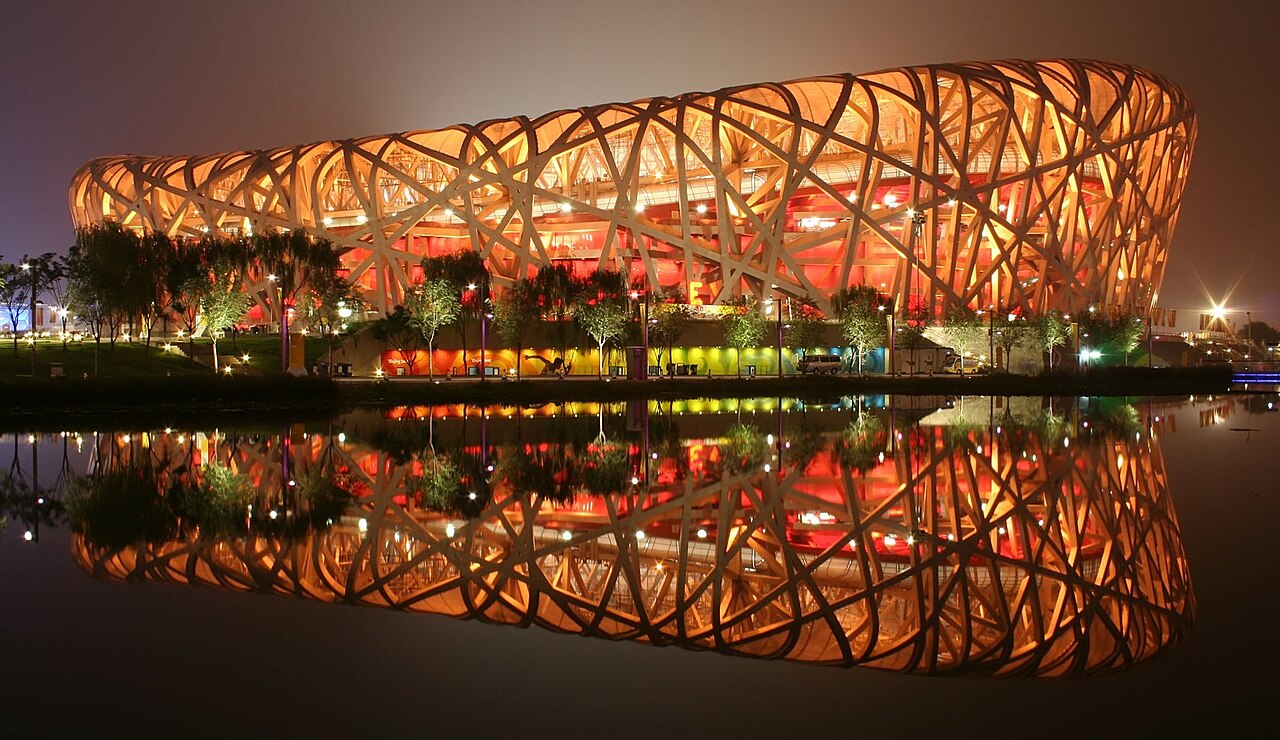 北京国家体育场鸟巢的夜景,灯光照亮了其独特的钢结构。