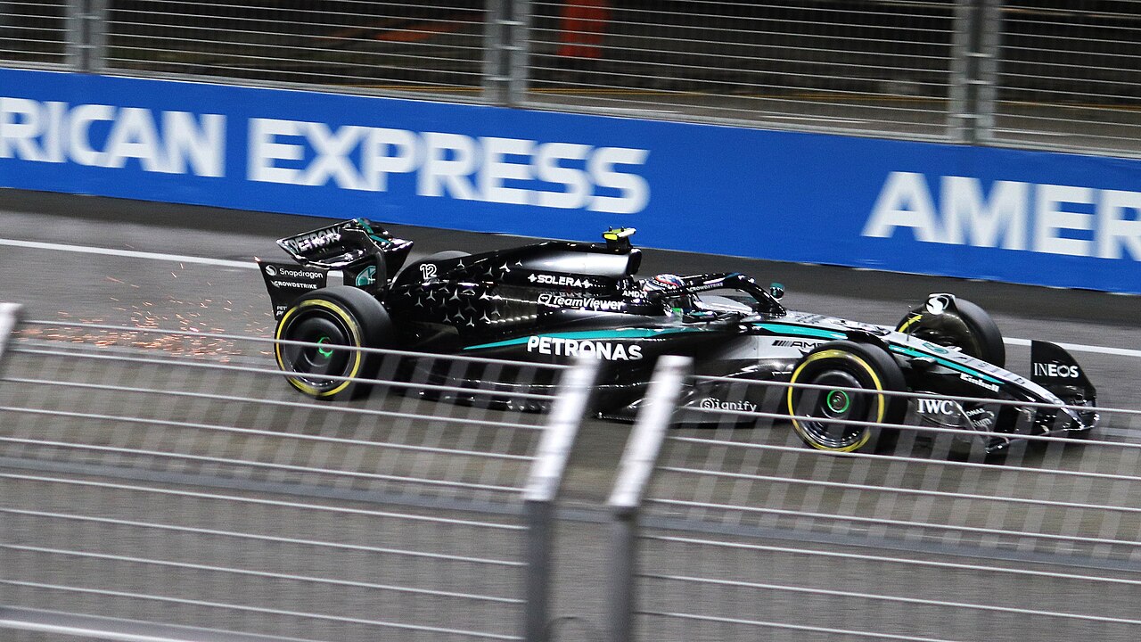 Un monoplaza de Fórmula 1 de Mercedes circulando a alta velocidad por un circuito urbano.