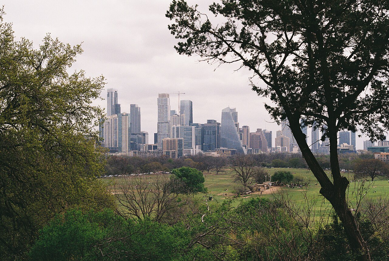 Vista panorámica diurna de los rascacielos de la ciudad de Austin rodeados por vegetación.