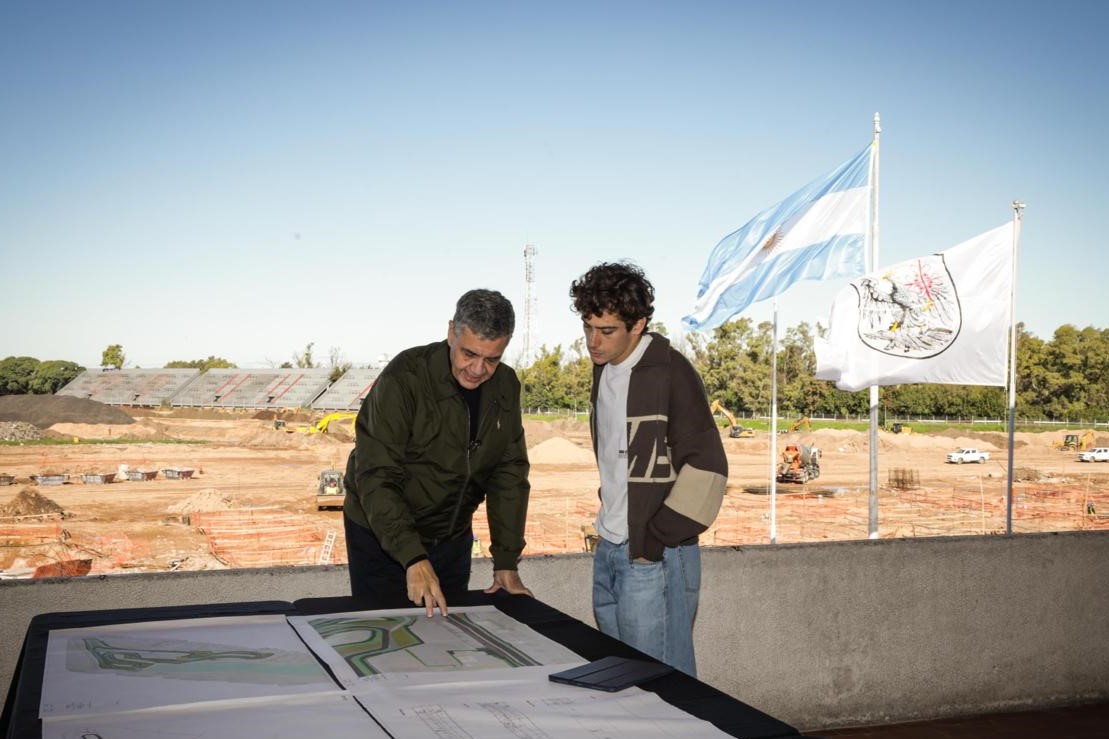 Franco Colapinto observa planos de un autódromo junto a un hombre en una zona elevada.