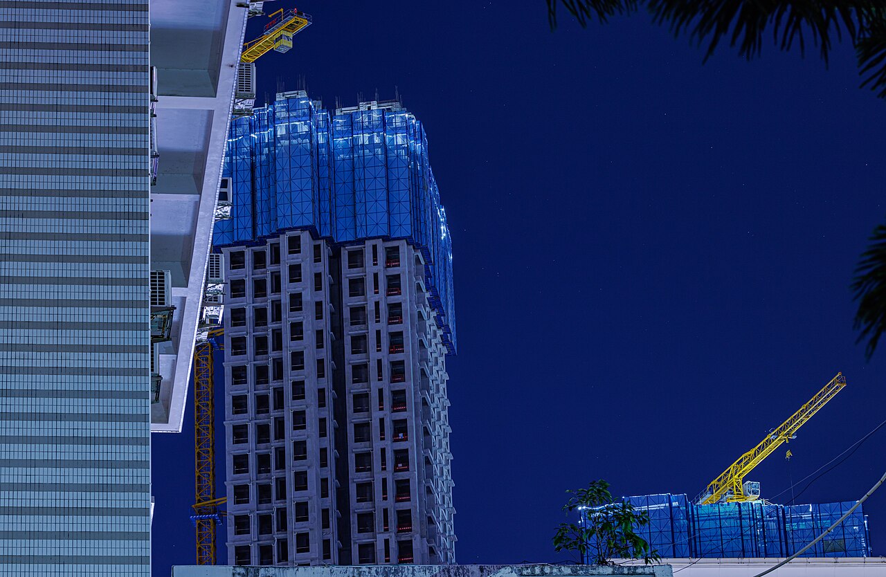 Edificio en construcción de Evergrande con grúas bajo un cielo nocturno en Shenzhen.