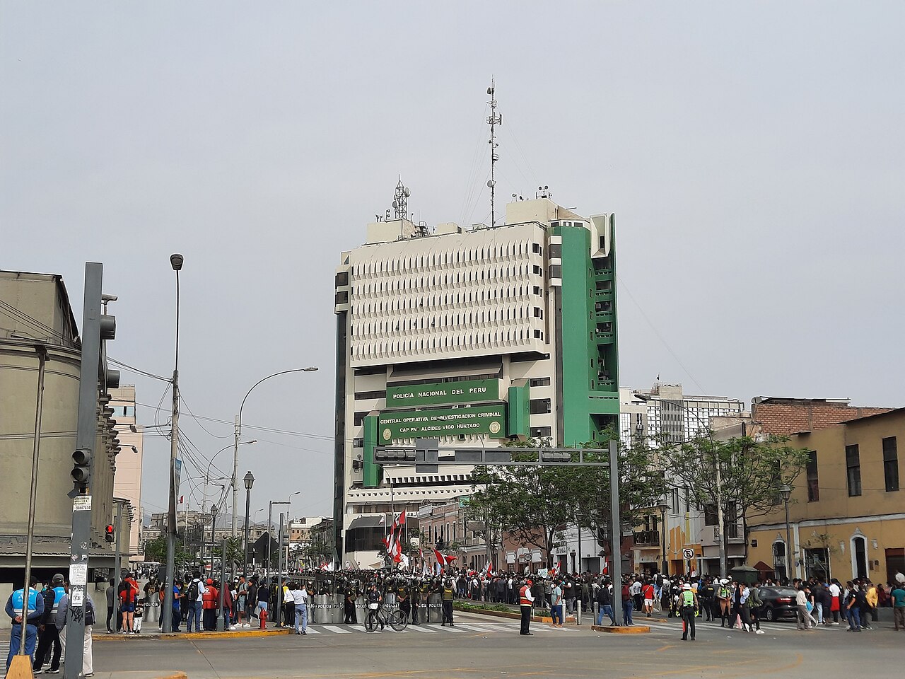Edificio gubernamental de la policía en Lima rodeado por una multitud de personas protestando.