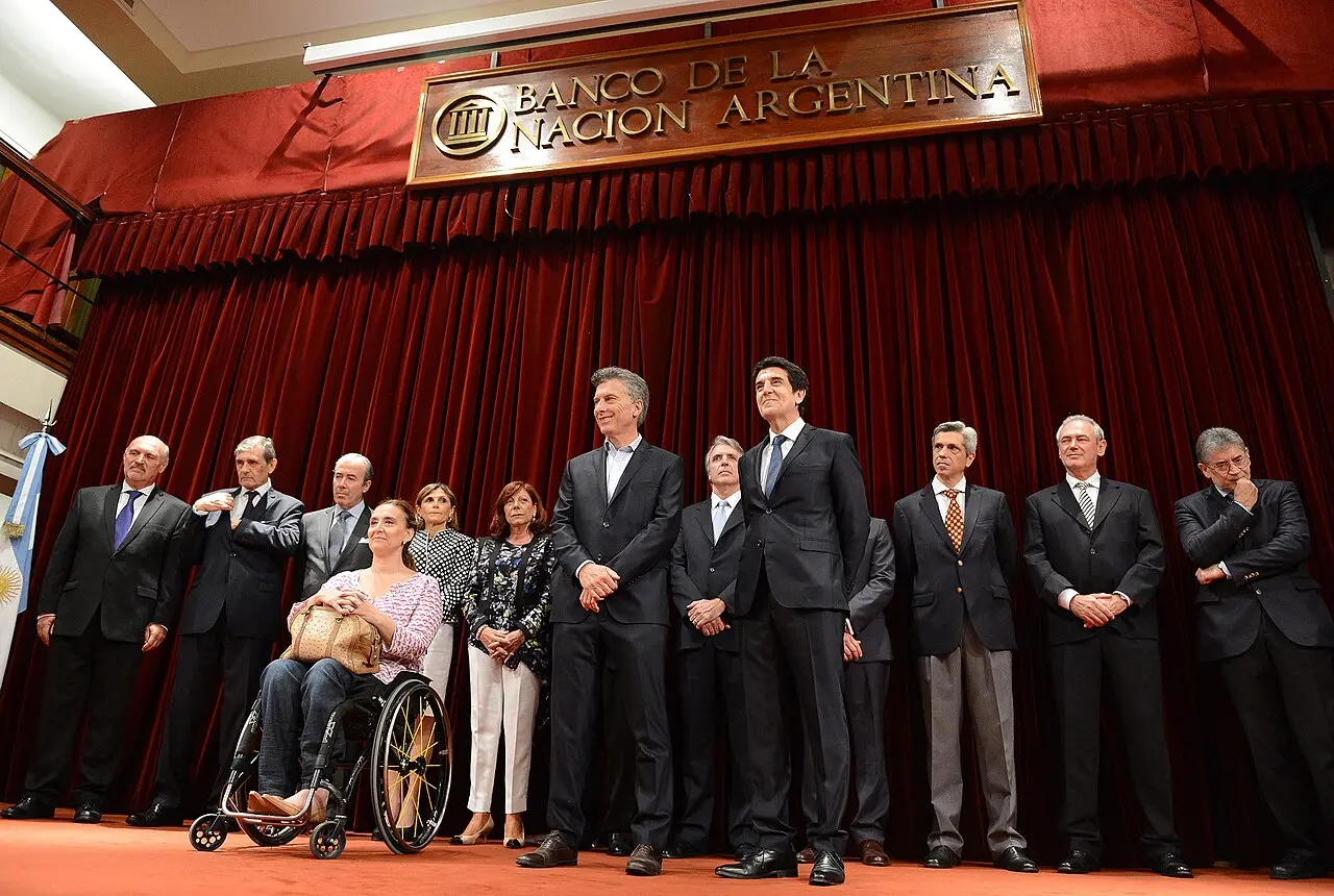 El economista Carlos Melconian junto a un grupo de personas en un acto oficial.