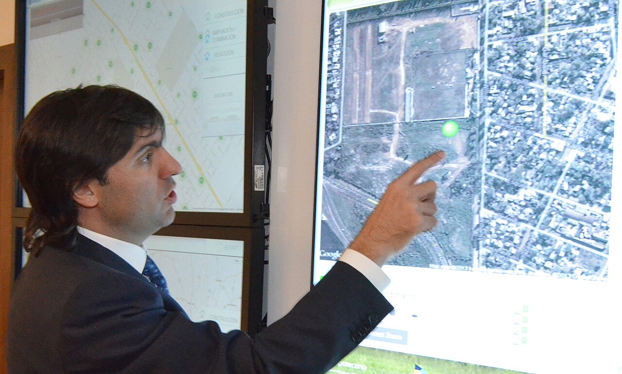 Diego Bossio señala un mapa proyectado en una pantalla durante una presentación oficial de trabajo.