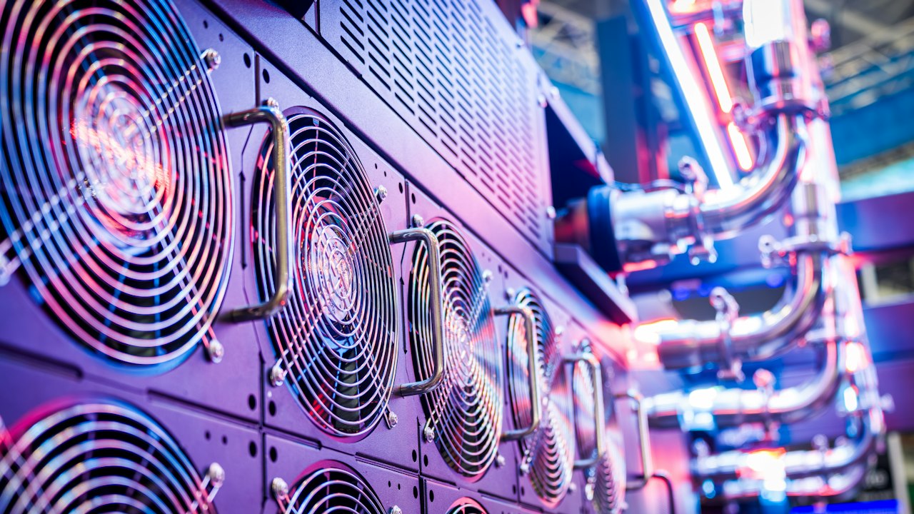 Primer plano de ventiladores de refrigeración en un centro de datos con luces azules.
