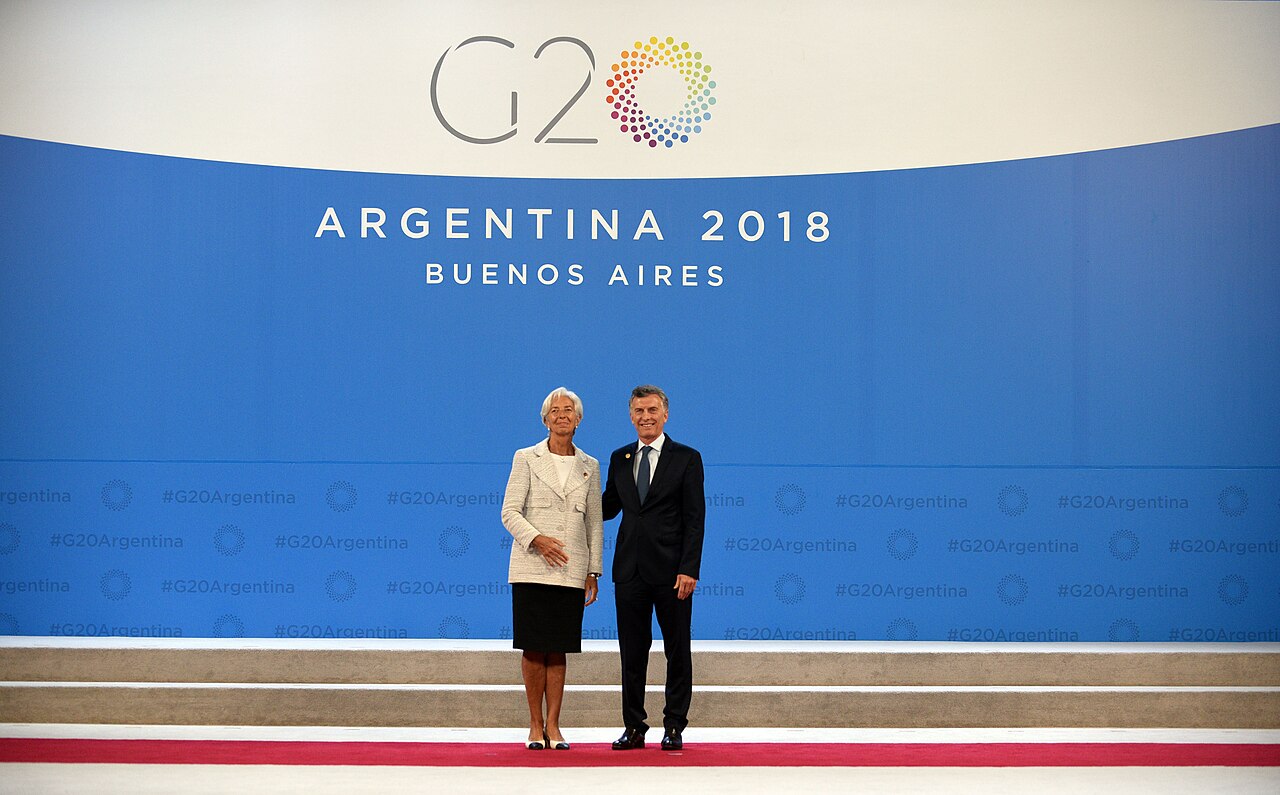 Christine Lagarde y el expresidente argentino posan juntos frente a un cartel azul institucional.