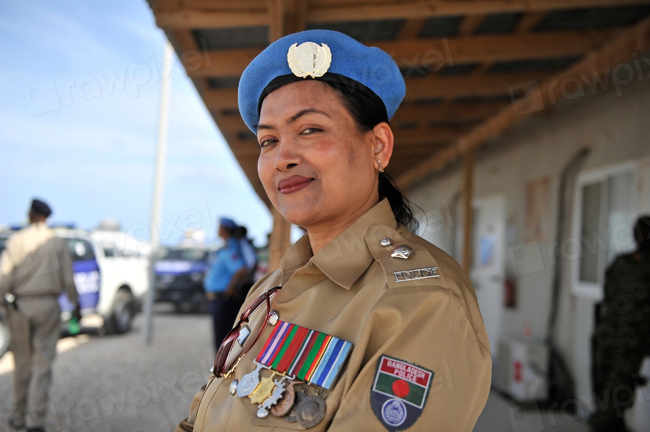 Una oficial de policía con uniforme y boina azul posa frente a la cámara.