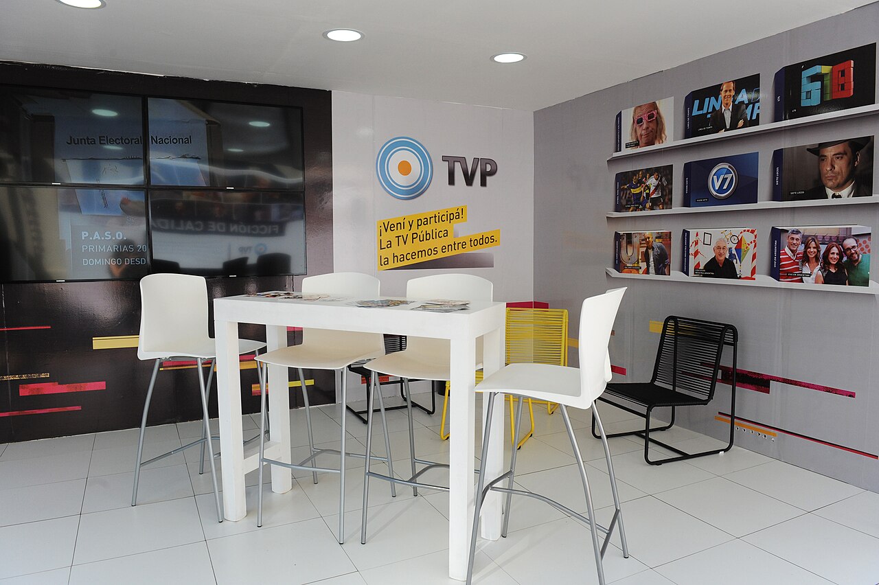 Mobiliario moderno de oficina en un stand de exposiciones con sillas blancas y mesas.