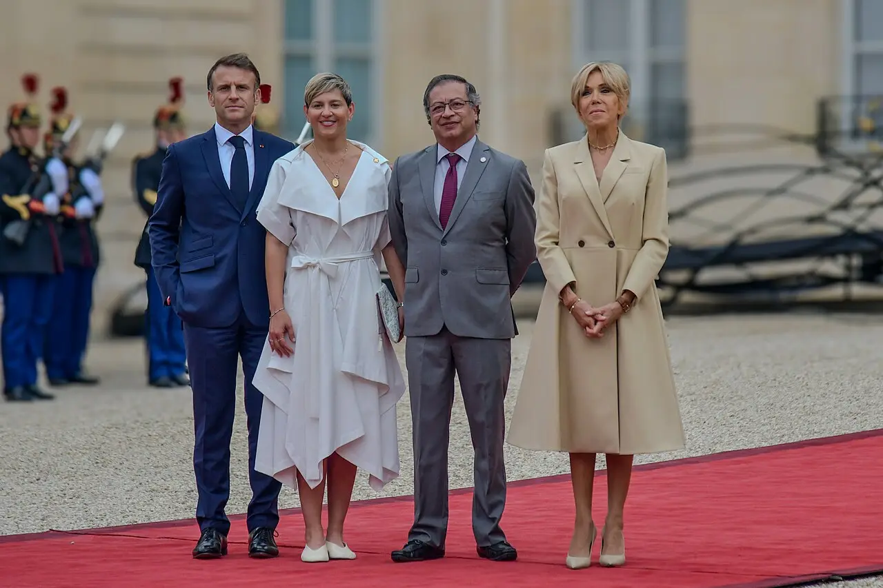 Emmanuel Macron y su esposa reciben a una pareja en la entrada del Palacio Elíseo.