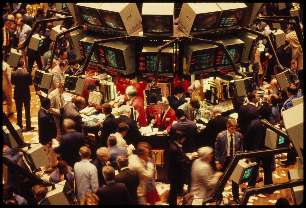 Operadores financieros trabajando intensamente en el piso de remates de la Bolsa de Nueva York.