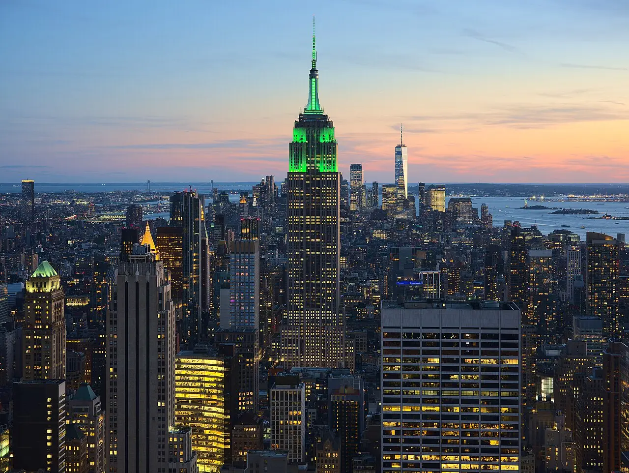 Vista panorámica nocturna de los rascacielos de Nueva York con el Empire State iluminado.