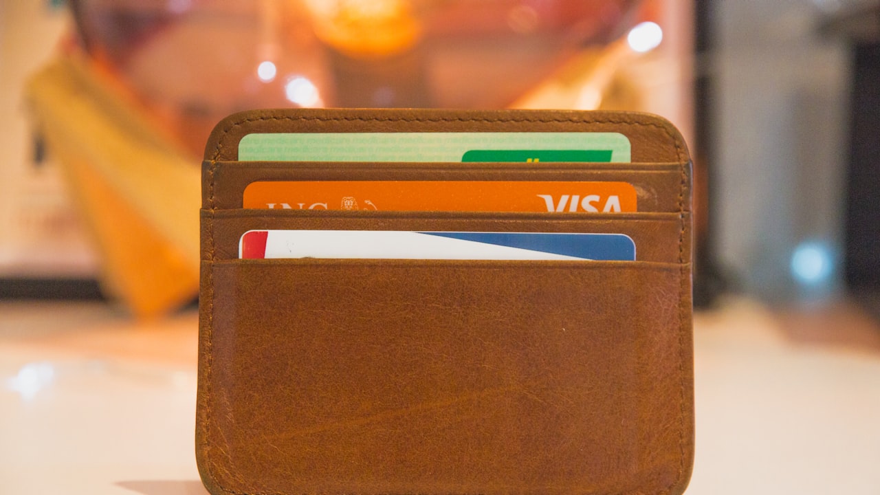 Una billetera de cuero marrón con varias tarjetas de crédito visibles en su interior.