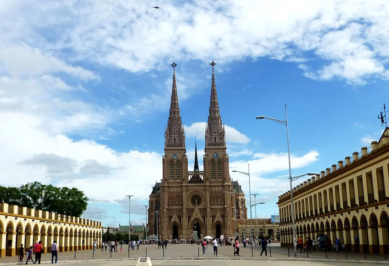 La imponente Basílica de Luján se alza bajo un cielo despejado con personas caminando alrededor.