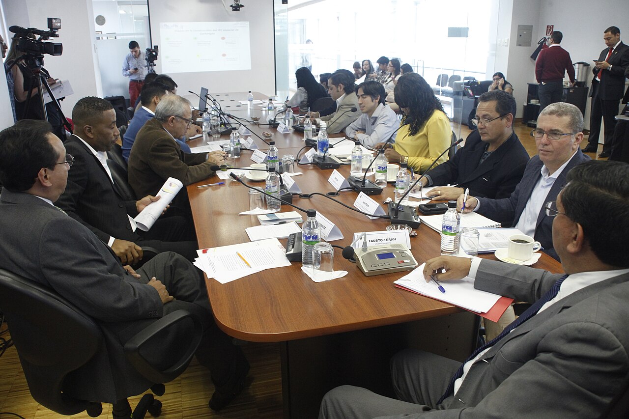 Funcionarios reunidos en una mesa de trabajo analizando informes estadísticos y documentos oficiales.