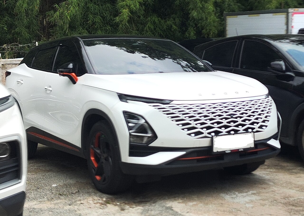 Un vehículo Chery Omoda de color blanco estacionado en un espacio al aire libre.