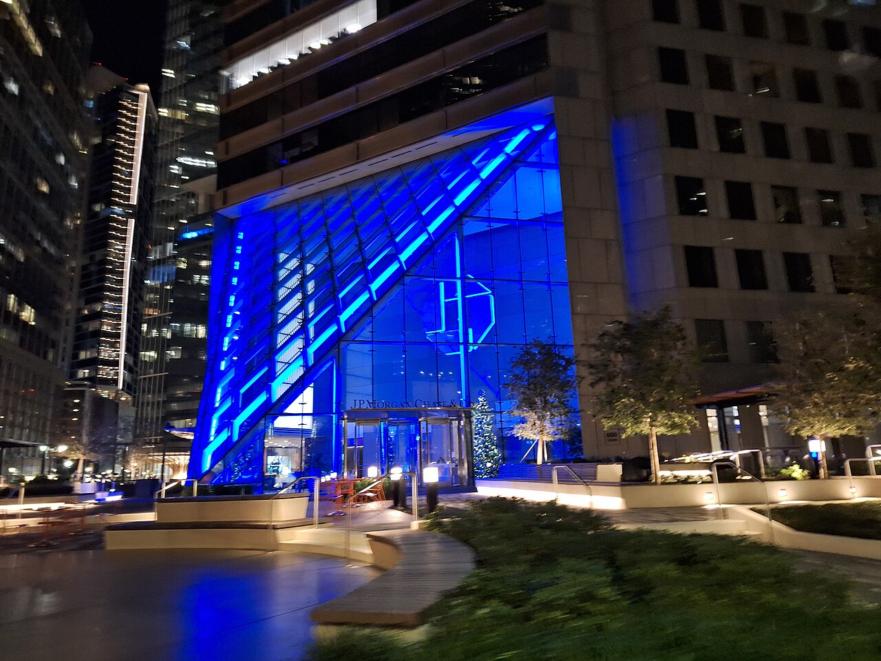 一座点缀着蓝色灯光的现代企业办公楼夜景外观。