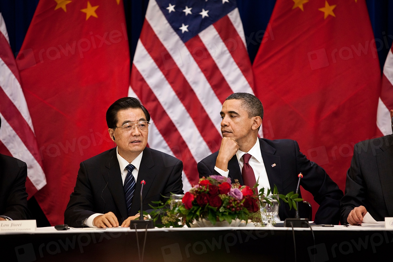 El expresidente Barack Obama junto a un funcionario chino en una mesa de negociaciones diplomáticas.