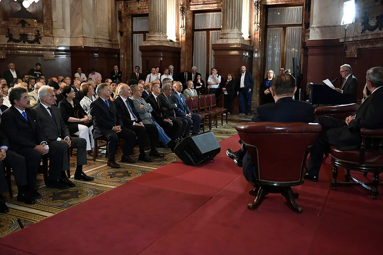 Vista general de un salón del Senado con personas sentadas escuchando a un orador.