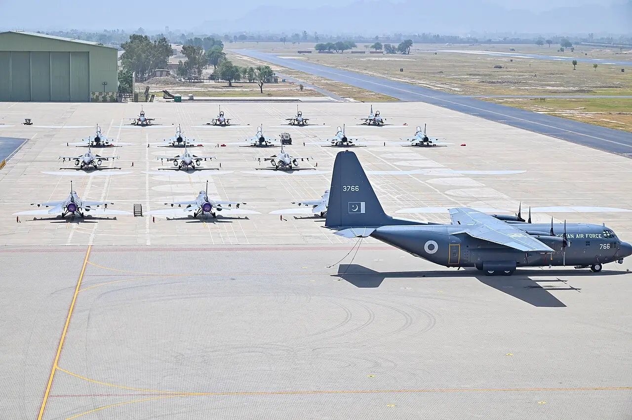 Varios aviones de combate estacionados en una pista de aterrizaje militar durante un ejercicio.