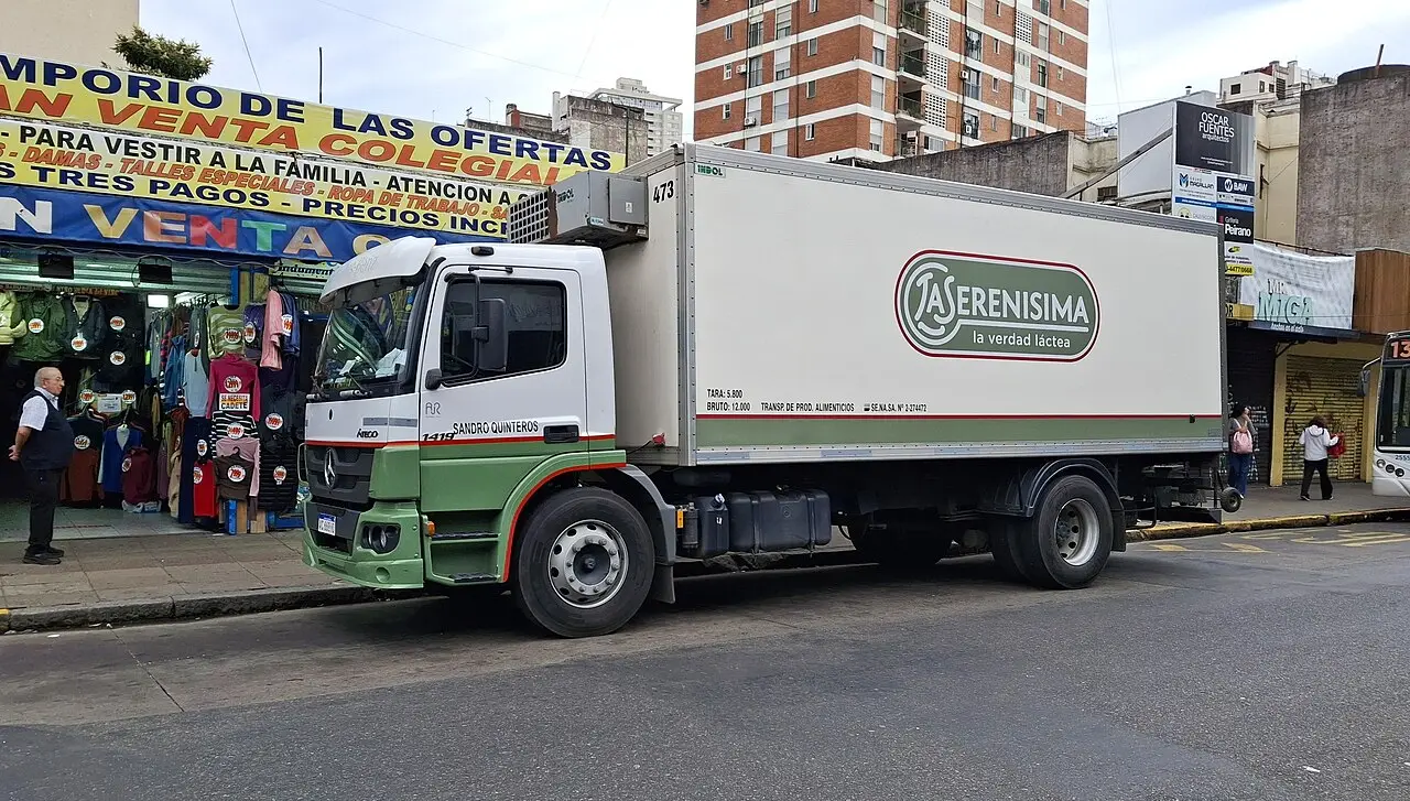 Un camión de reparto de la empresa láctea La Serenísima estacionado en una calle urbana.